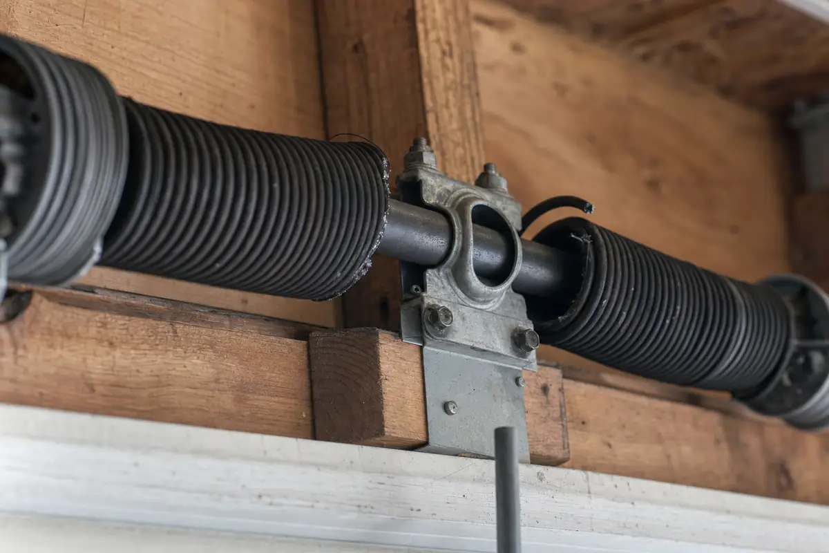 A snapped torsion spring on the shaft above a garage door